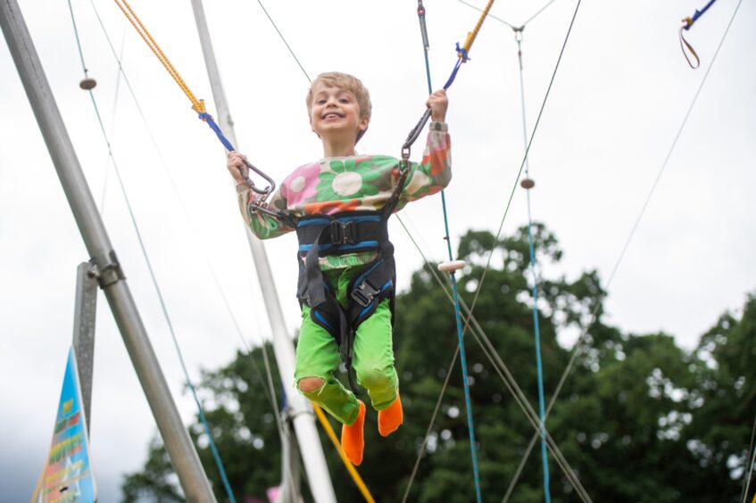 A young visitor to the Braco Show enjoys a bungie bounce.