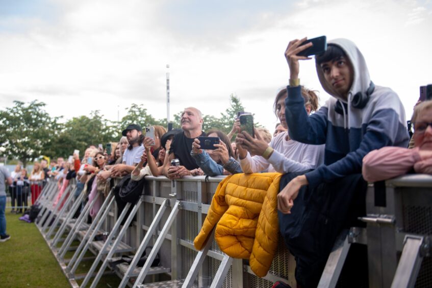 Fans at the front row take pictures of Tom Jones.
