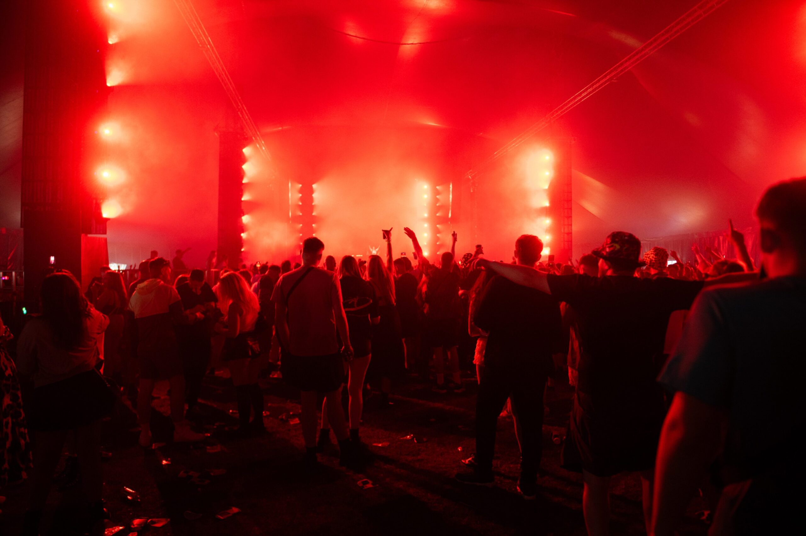 Crowd dancing under intense red lighting inside a festival tent at Doof in the Park 2025, Camperdown Park, Dundee.