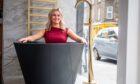 Staff member Cia Neser tries the black stone bath in the new showroom. Image: Kim Cessford / DC Thomson