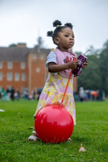 Toddler Ini Bada, aged 21 months, stands with a juice carton at the Afro-Caribbean Summer Festival in Dunfermline.