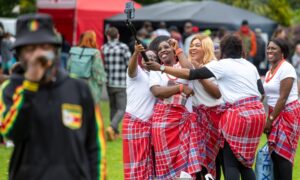 Igbo Amaka Ladies Cultural Group dressed in traditional red wrappers take a group selfie at the Afro-Caribbean Summer Festival in Dunfermline.