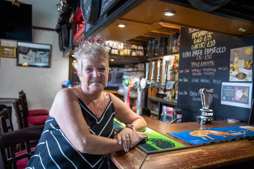 Karen Begg, the Auld Hoose pub manager, sits at the bar