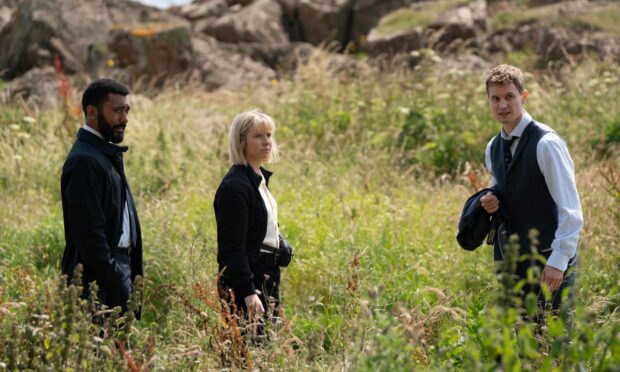 Image shows the cast of Karen Pirie season two in a field in Fife.