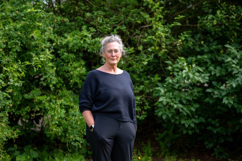 Emily Crichton standing in front of green shrubs