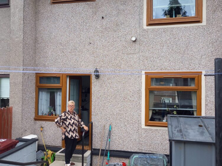 Margaret McLeod at the back door of her home.