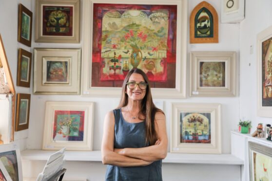 Image shows painter Morag Muir with some of her work.