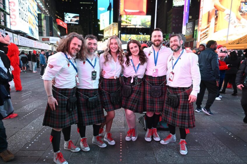 Six people in kilts in Times Square