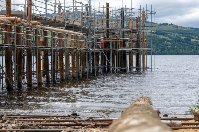 Wooden walkway leading to round wooden structure in Loch Tay