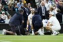 Grigor Dimitrov (centre) reacts as he receives treatment for an injury during his Gentlemen's Singles match against Jannik Sinner (right) on day eight of the 2025 Wimbledon Championships at the All England Lawn Tennis and Croquet Club, London. Picture date: Monday July 7, 2025.