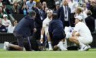 Grigor Dimitrov (centre) reacts as he receives treatment for an injury during his Gentlemen's Singles match against Jannik Sinner (right) on day eight of the 2025 Wimbledon Championships at the All England Lawn Tennis and Croquet Club, London. Picture date: Monday July 7, 2025.