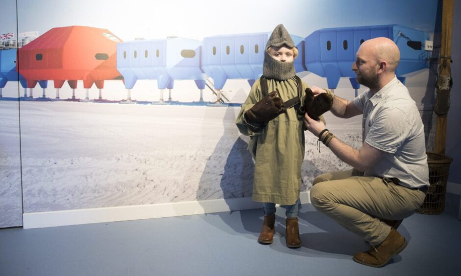 A young visitor trying on some Antarctic exploration gear at Discovery Point.