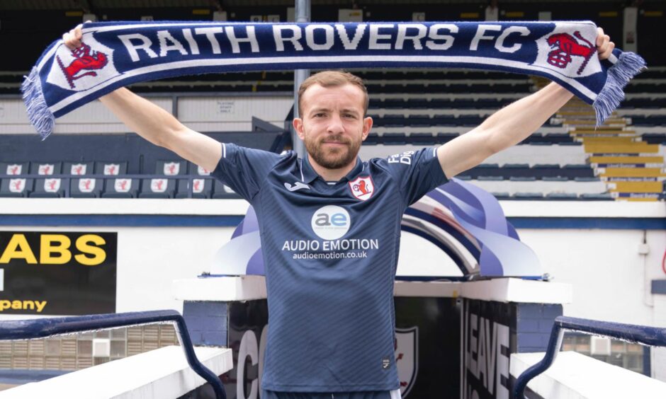 Paul McMullan stretches a Raith Rovers FC scarf above his head.