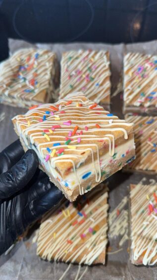 Taylor Young holding a funfetti cake.