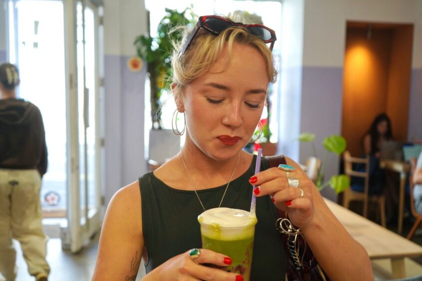 A woman enjoying a matcha from EH9