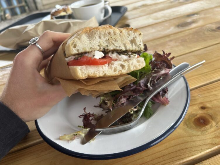 The focaccia sandwich served on a plate with a side salad.