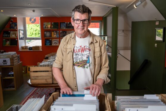 Colin Tennent rifling through crate of records at Foot of the Mountain Records shop