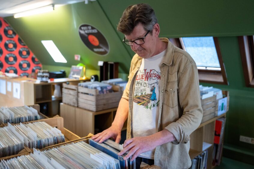 Colin Tennant leafing through record box in Foot of the Mountain Records