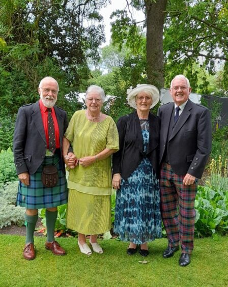 Peter and Sheila Cookson with guests Catherine and Callum Beaton standing in front of flowerbed