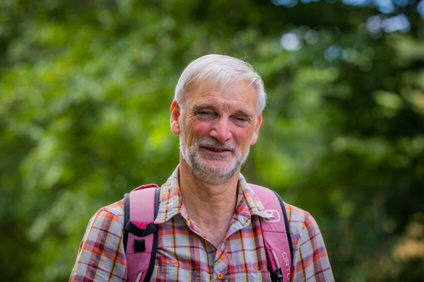 Martin Downing in checked shirt with rucksack on shoulders