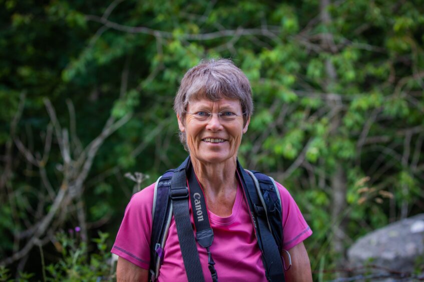 Felicity Martin in pink t shirt with camera strap around neck