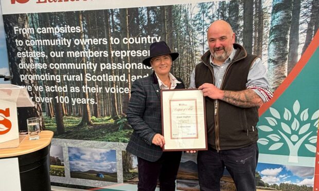 Scottish Land & Estates chief executive Sarah-Jane Laing presents Grant Stephen with his long service award.