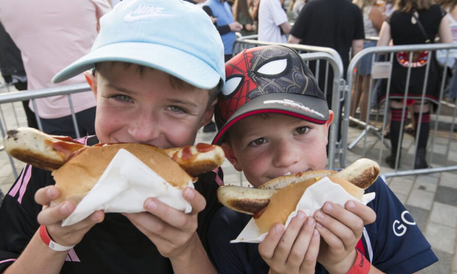 Two boys tucking into hot dogs at the Sausage and Cider Festival in Dundee .