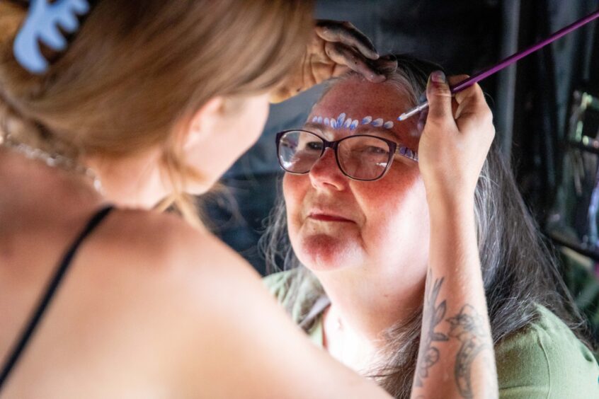 An attendee at the Discovery Festival in Dundee has her face painted by one of the vendors.
