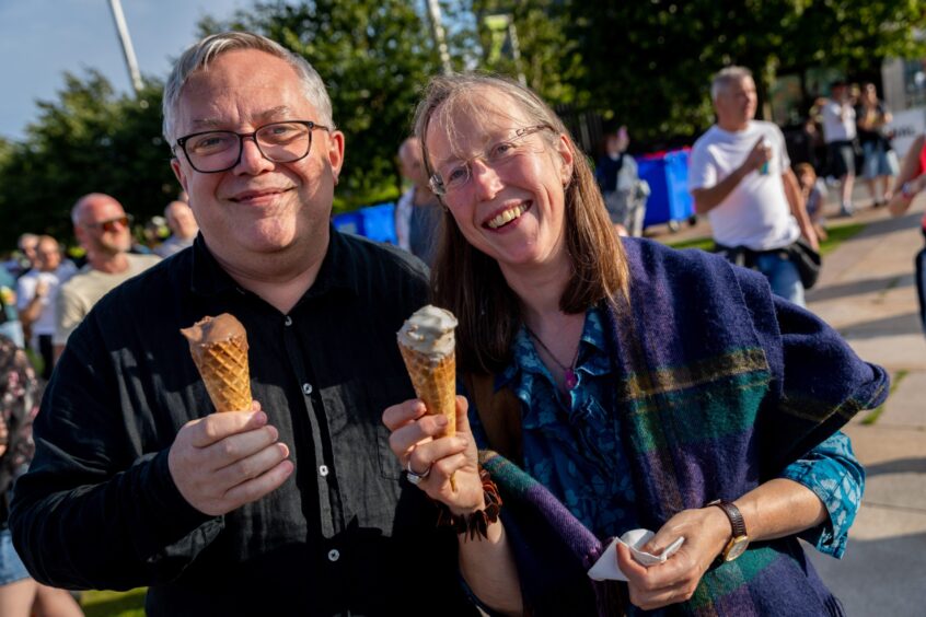 A happy couple enjoy an ice cream.