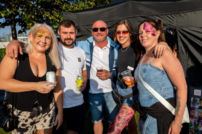 Group of friends enjoying a drink in the sun at Dundee's Discovery Festival.