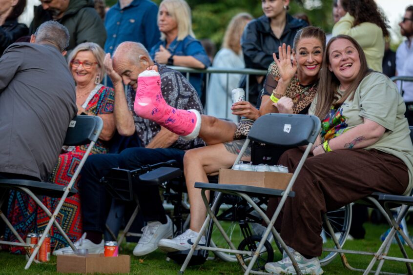 A dedicated fan in a pink leg cast enjoys Ocean Colour Scene.