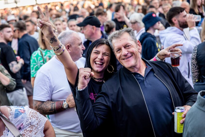 A man and woman salute the performers.