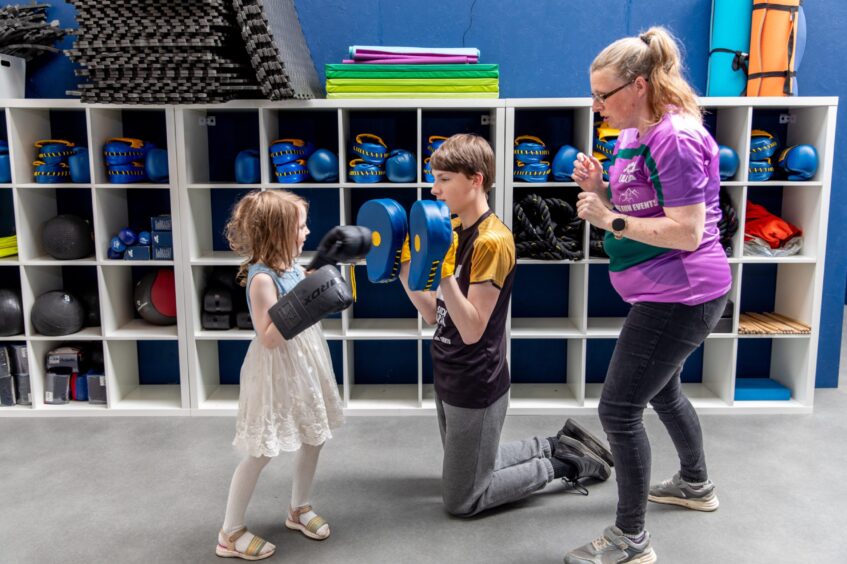 Olly (5) practicing Boxercise with Sully (13) holding a pad at Perth Fitness Studios.