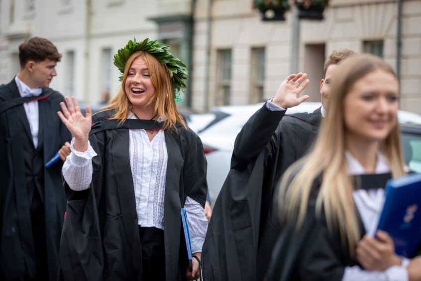 Smiles and waves as graduates make their way to St Salvator's Quad.