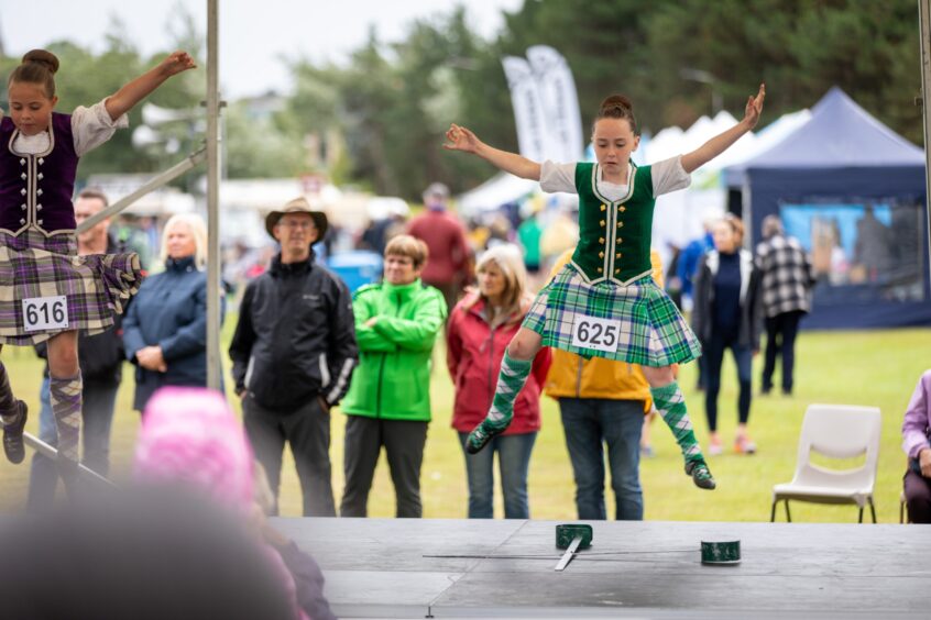 Judges watch on as Highland dancers perform at the St Andrews Highland Games.