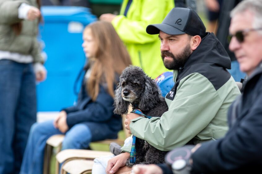 A man and his dog enjoy the St Andrews Highland Games.