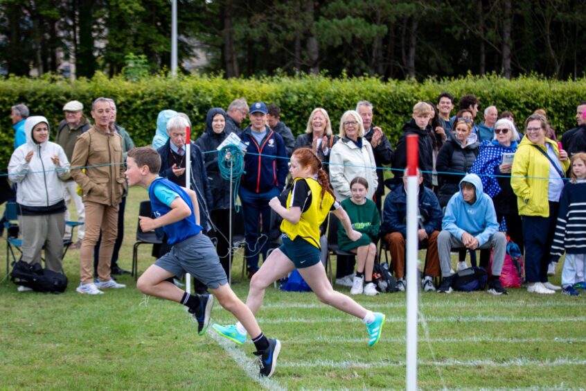 Young runners cross the finishing line at St Andrews Highland Games.