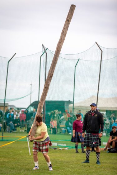 A woman gets ready to toss the caber at St Andrews Highland Games.