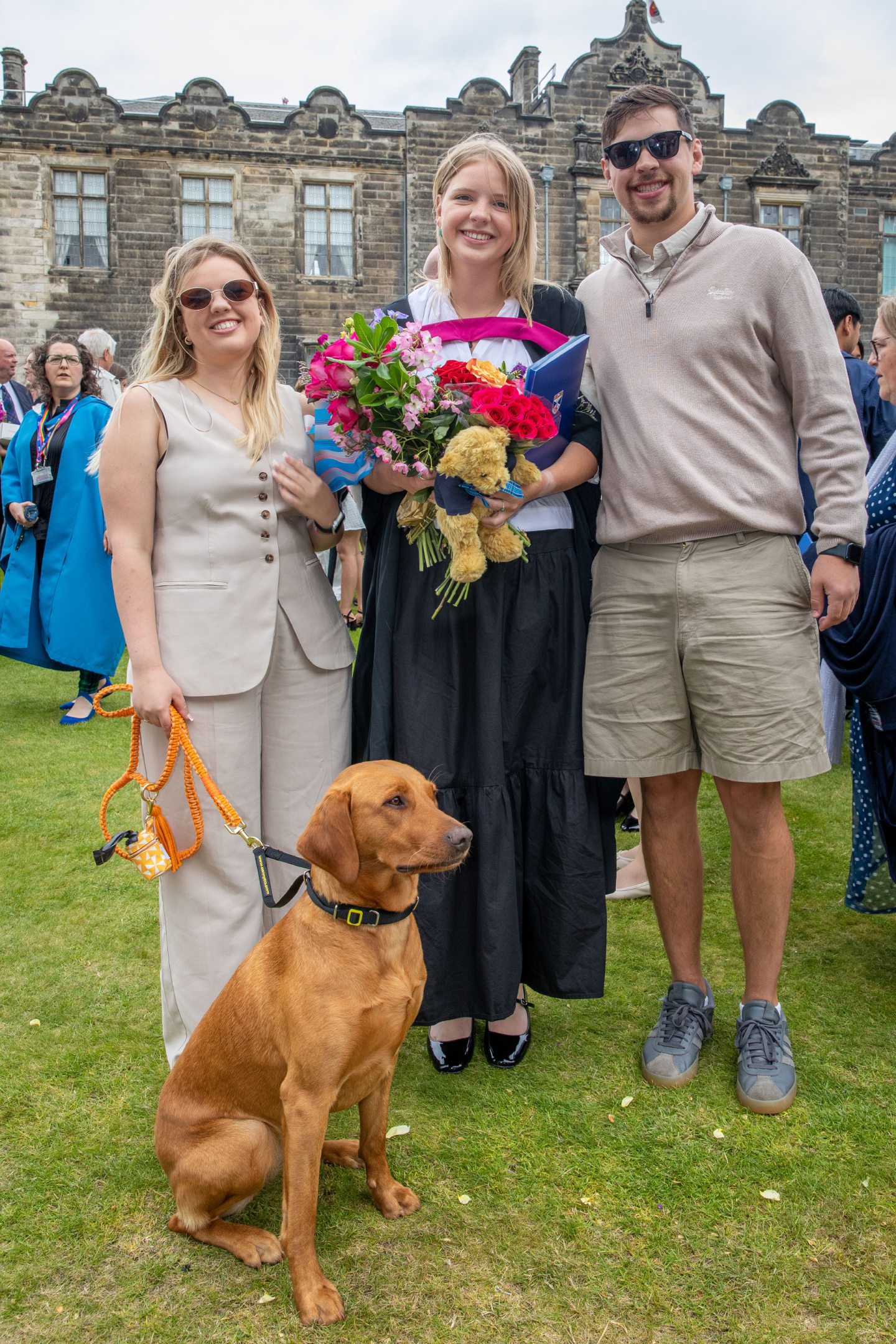 Sophie Bergeron with siblings Tara and Stephane and their dog Coda, posing with flowers and certificates in St Salvator’s Quad at St Andrews University.