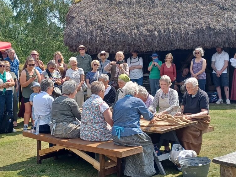 visitors watch as actors reenact life in the Highlands back in the day