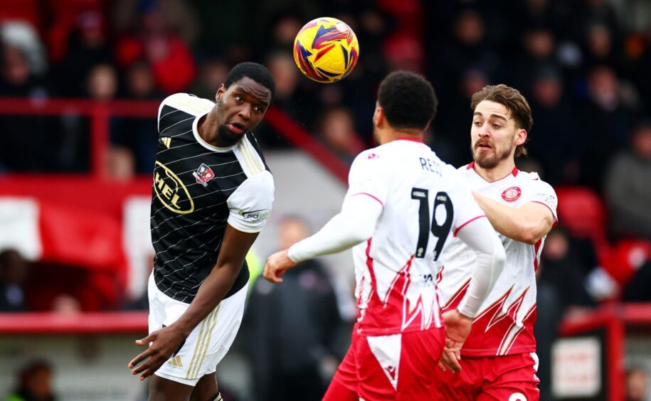 Cheick Diabate heads a ball clear for Exeter City.
