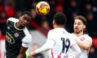 Cheick Diabate heads a ball clear for Exeter City.