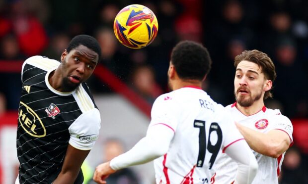 Cheick Diabate heads a ball clear for Exeter City.