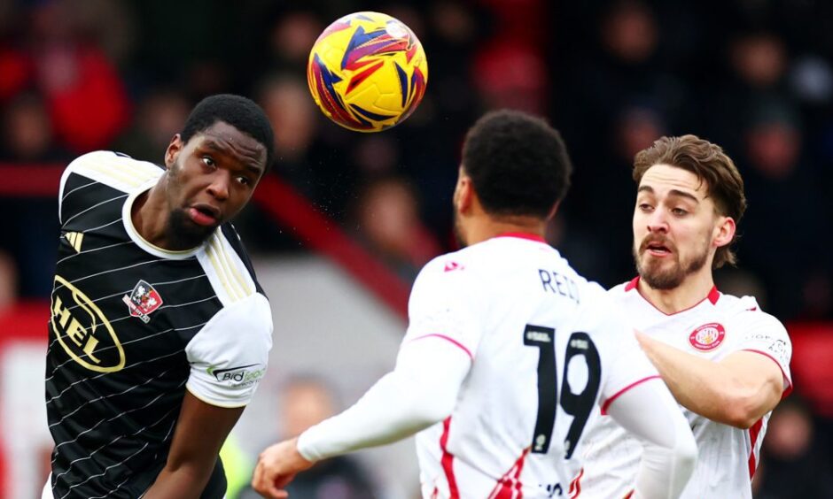 Cheick Diabate heads a ball clear for Exeter City.