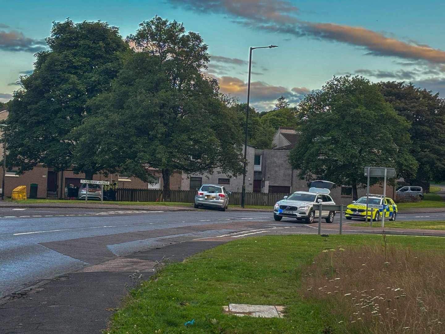 Police vehicles and the damaged car following the crash on Dalmahoy Drive, Dundee.