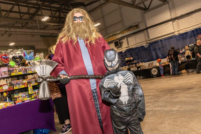 A man dressed as superhero Thor with a young boy dressed as Venom at Perth Comic Con 2025.