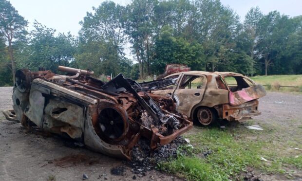 Two burned out cars, one on its roof, rest in the former golfers' car park at Caird Park. Image: Lindsey Hamilton/DC Thomson