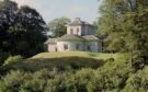 Old fashioned white building on slight slope surrounded by trees