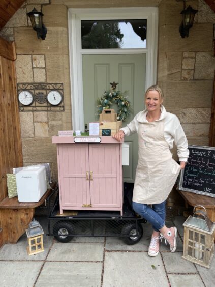 Claire Sara standing by her cake shed.