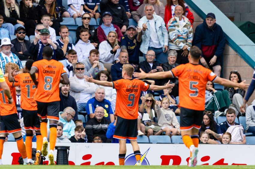 Zac Sapsford celebrates in front of the away fans.